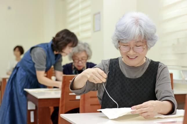 괴산군 웰다잉 프로그램에서 참가자들이 전통 한지로 수의를 만들고 있다
