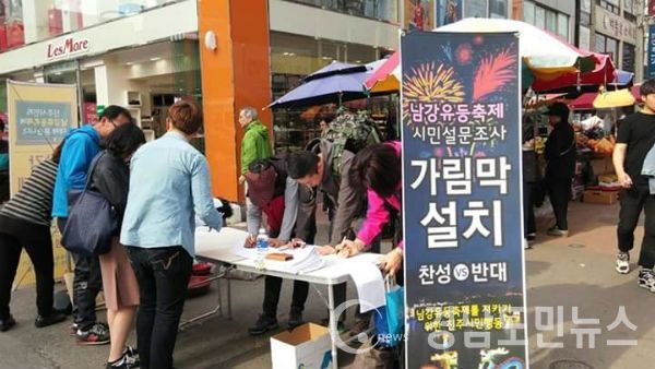 남강유등축제 지키기 위한 진주시민행동 연대모임이 중앙시장 앞에서 '가림막설치'에 대한 시민들의 의견을 설문지를 돌려 조사하고 있다.