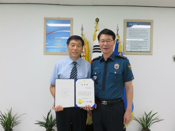 90대 할아버지의 보이스피싱 사기 피해를 막은 공로로 진주경찰서장으로부터 감사장을 받은 신한은행 중앙금융센터 청원경찰 박광재씨와 류재응 진주경찰서장의 모습/ 사진제공=진주경찰서