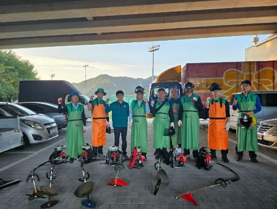 삼문동새마을지도자협의회가 풀베기 작업 전 기념촬영을 하고 있다.