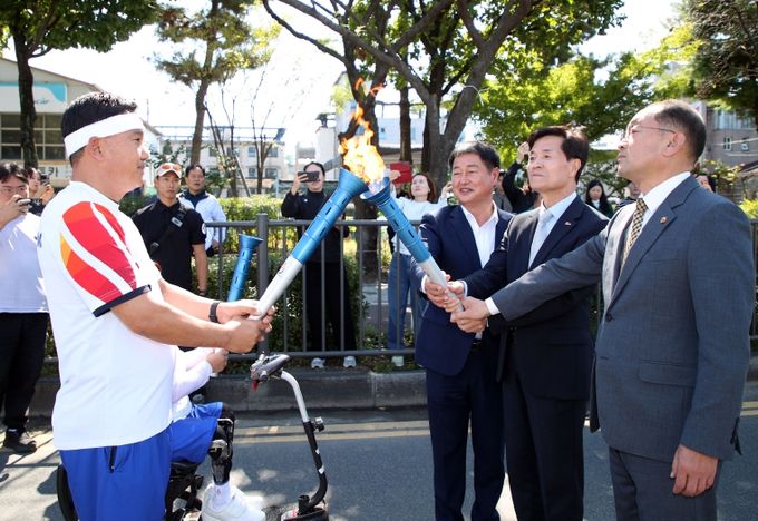 안병구 밀양시장(사진 우측 중앙), 박진수 밀양시의회 부의장(사진 우측 왼쪽), 민경갑 밀양시 체육회장(사진 우측 오른쪽)이 10일 밀양시청 앞에서 제105회 전국체전 및 제44회 전국 장애인체전 성화를 맞이하고 있다.