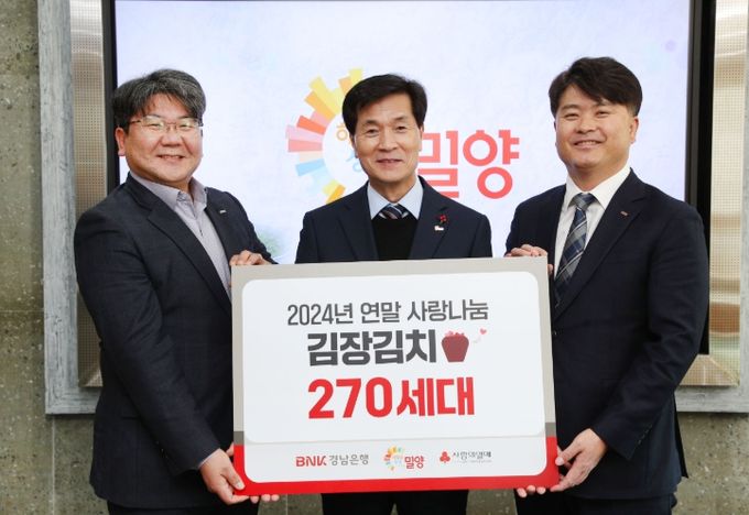 지난 9일 BNK경남은행 홍응일 고객기획본부장(사진 오른쪽)이 밀양시청을 방문해 1,080만원 상당의 김치 270박스를 밀양시(시장 안병구, 사진 가운데)에 기탁했다.
