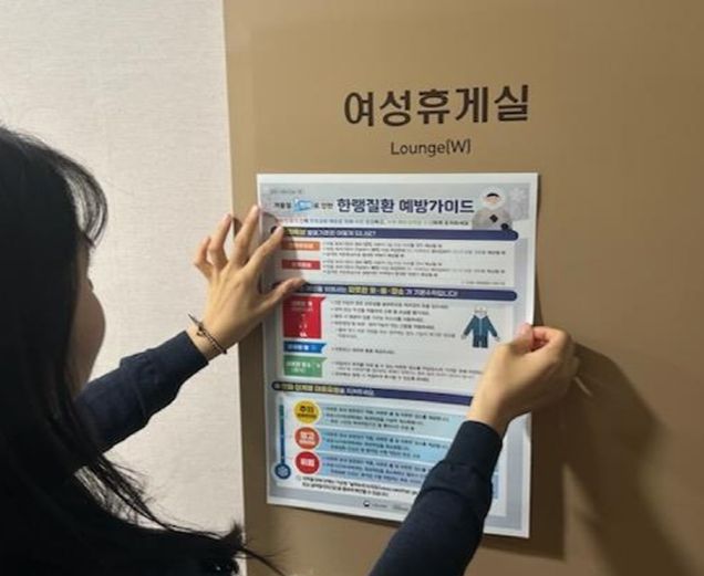교육청 관계자가 근로자 휴게실에 산업안전보건 포스터 게시하고 있다.
