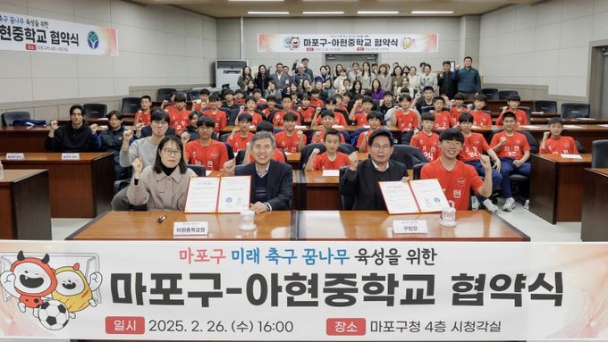 박강수 마포구청장이 마포구와 아현중학교 협약식에서 아현중 축구부 학생들과 기념촬영을 하고 있다.