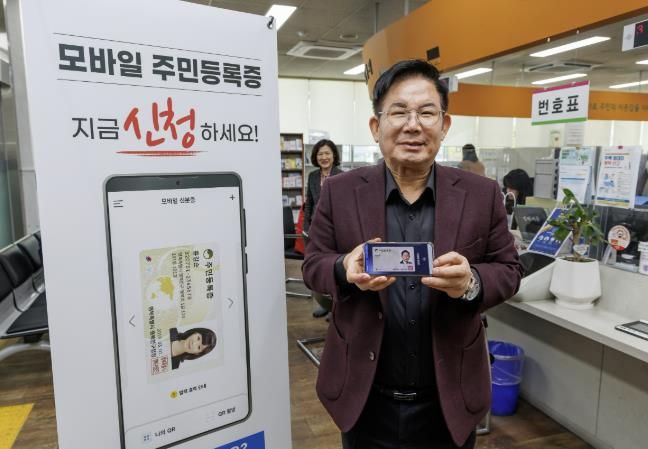 박강수 마포구청장이 3월 17일 오후 2시 서강동 주민센터를 방문해 발급받은 모바일 주민등록증을 들어 보이고 있다