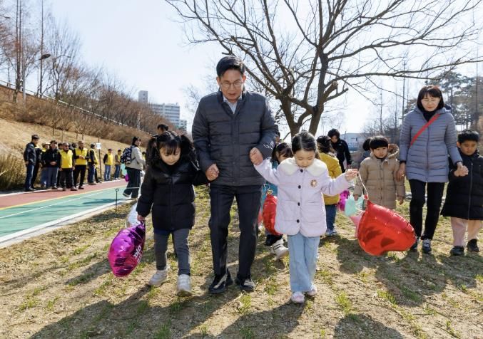 박강수 마포구청장이 어린이집 원아들과 함께 월드컵천에서 보리밟기를 하고 있다