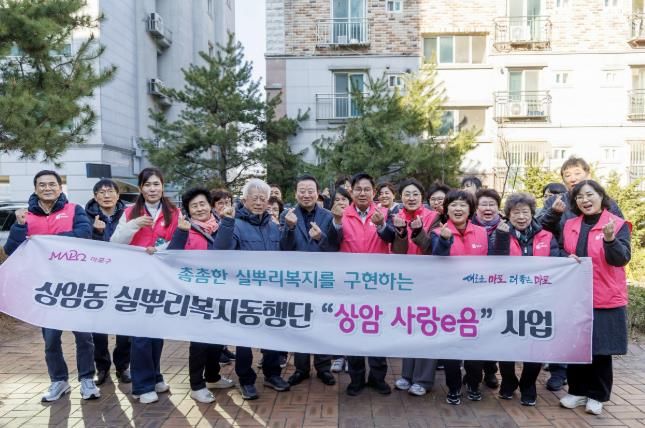 박강수 마포구청장이 2025년 3월 19일 오후 4시부터 상암동에서 열린 ‘상암 사랑e음’ 주거환경개선사업에 참여하여 상암동 실뿌리복지동행단과 사진을 찍고 있다