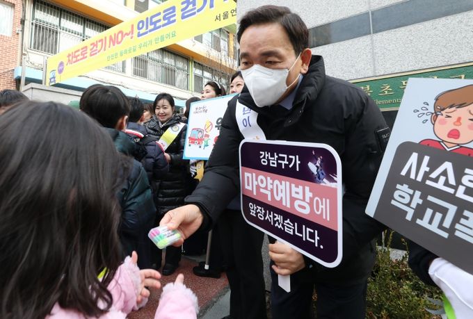 언북초등학교 앞에서 아동·청소년 캠페인 현장에서 학생에게 학용품을 건네고 있는 조성명 강남구청장