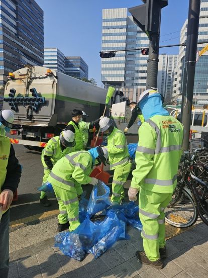 청소 후 쓰레기를 수거하는 환경공무관