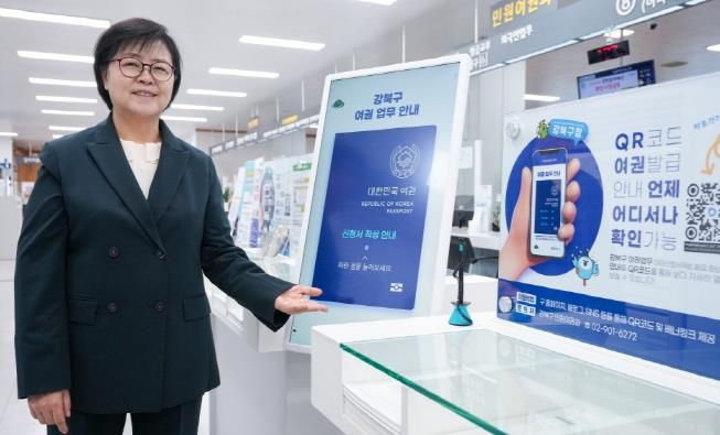 이순희 강북구청장이 강북구청 1층 민원실에 게시된 여권 발급 안내 디지털 사이니지를 소개하고 있다