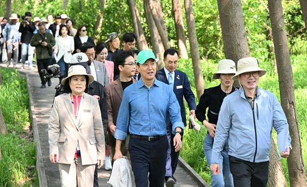 오세훈 서울시장이 29일(화) 열린 ‘암사초록길 개통식’에서 참석자들과 함께 걷고 있다.