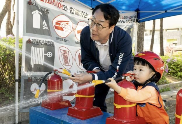 정명근 화성특례시장이 화성특례시 어린이날 영유아가족 어울림축제에서 어린이와 함께 소화기 사용 체험을 하고 있다.