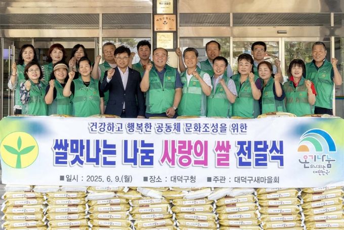 (사진 맨 밑줄 왼쪽 세 번째부터) 안귀숙 대덕구새마을부녀회장, 최충규 대덕구청장, 박광수 대덕구새마을회장, 양승재 대덕구새마을지도자협의회장, 오세은 대덕구직장공장협의회장 및 관계자들이 대덕구청 현관 앞에서 사랑의 쌀 전달식 기념사진을 촬영하고 있다.