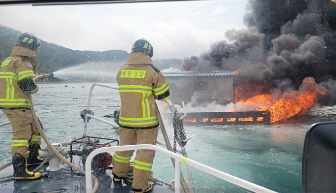 사천해경이 미조북항 인근 양식장 작업 뗏목에 발생한 화재 진화 작업 중인 모습