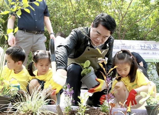 난곡로 사계절 생생정원 준공식에서 아이들과 함께 초화를 심는 박준희 관악구청장