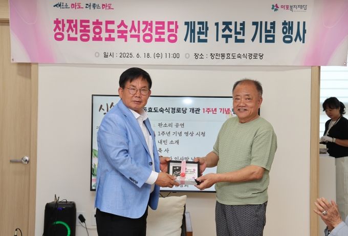 창전동 효도숙식 경로당 입주 어르신이 박강수 마포구청장에게 직접 만든 자개 액자를 선물하고 있다.