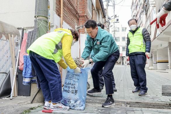 오언석 도봉구청장이 주민들과 함께 빗물받이를 청소하고 있다.