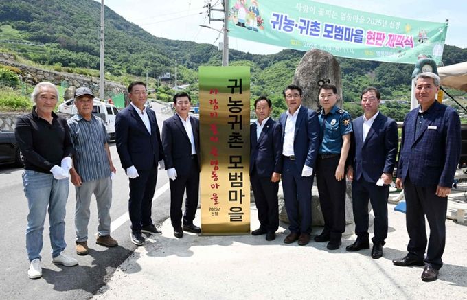 지난 19일 삼랑진읍 염동마을에서 열린 귀농·귀촌 모범마을 현판식 기념 촬영