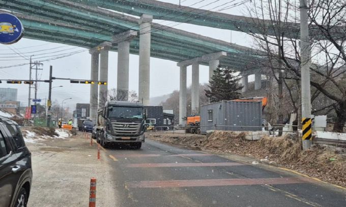 용인특례시 수지구 고기동의 노인복지주택 공사현장에 지난 3월 한시적으로 허용됐던 토사 반출 당시 고기초 앞 도로를 지나는 공사차량