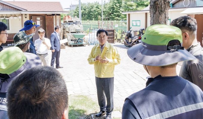 진교훈 서울 강서구청장(가운데 민방위복)이 공원녹지 현장 근로자를 만나 폭염 대응 수칙을 준수할 것을 당부하고 있다.