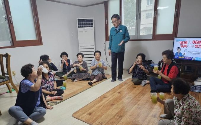 주영홍 밀양시 내이동장이 남부경로당을 방문해 사탕수수 음료를 전달하며 안전 점검과 함께 어르신들에게 안부를 전하고 있다.