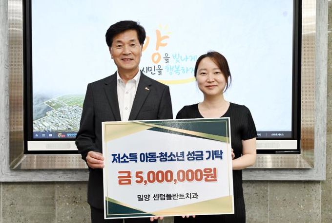 박언정 밀양 센텀플란트치과 원장(오른쪽)이 21일 시장실을 방문해 저소득 아동·청소년을 위한 성금 500만원을 기탁하고 있다.