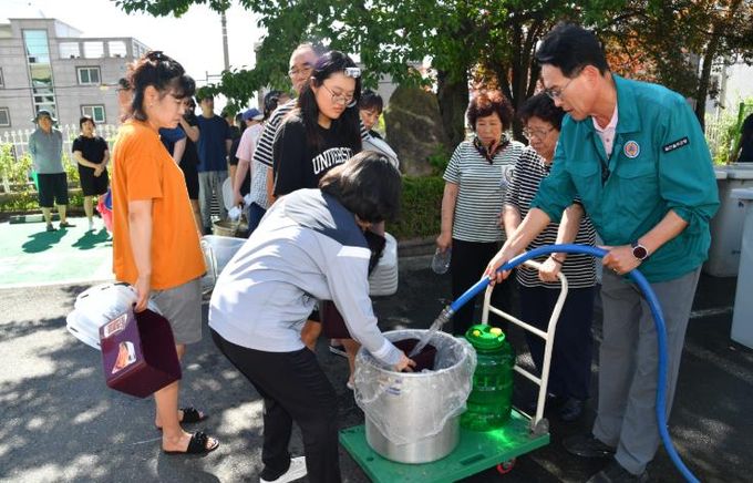 울산 울주군이 최근 집중호우로 인한 단수 피해지역의 물 공급을 위해 지난 20일부터 전 직원 비상근무를 실시 중인 가운데 이순걸 울주군수가 22일 삼남읍 한 공동주택에서 단수 피해주민들에게 생활용수를 나눠주고 있다.