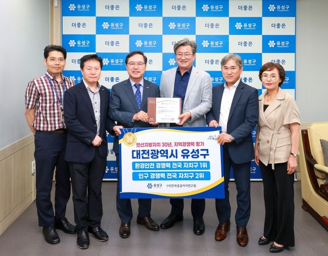 정용래 유성구청장(오른쪽에서 세번째)이 24일 한국공공자치연구원 이기헌 대표이사(왼쪽에서 세번째)로부터 지역경쟁력 최우수기관 인증패를 전달받고 있다.