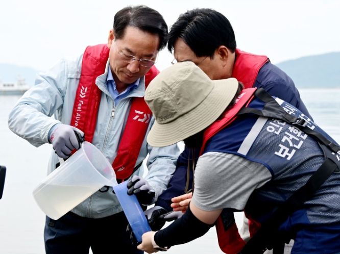 유정복 인천광역시장이 30일 강화군 외포항에서 해수를 채취하고 있다.