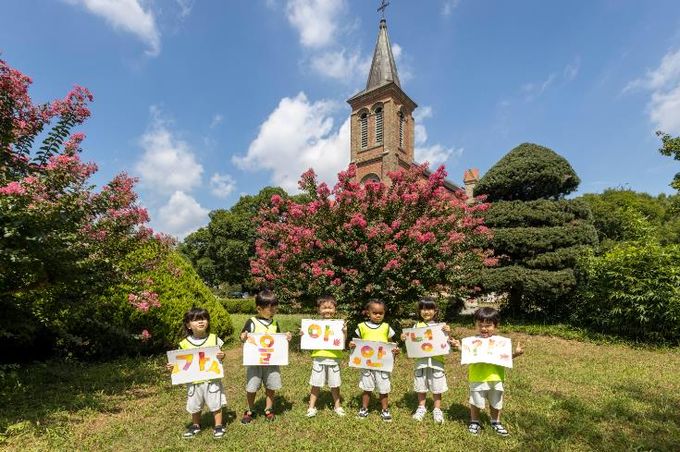 칠곡 가실성당에서 활짝 핀 백일홍 앞에서 왜관읍 동산애 어린이집 원아들이‘가을아 안녕’이라는 손피켓을 들고 환하게 웃고 있다.