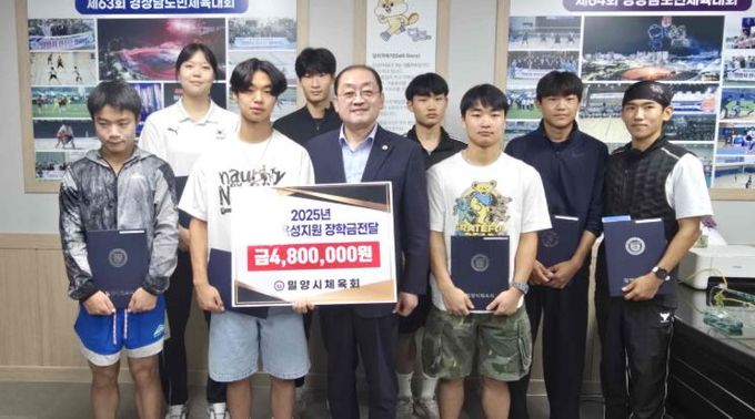 장학금을 받은 학생들이 민경갑 밀양시체육회장과 함께 기념 촬영을 하고 있다.