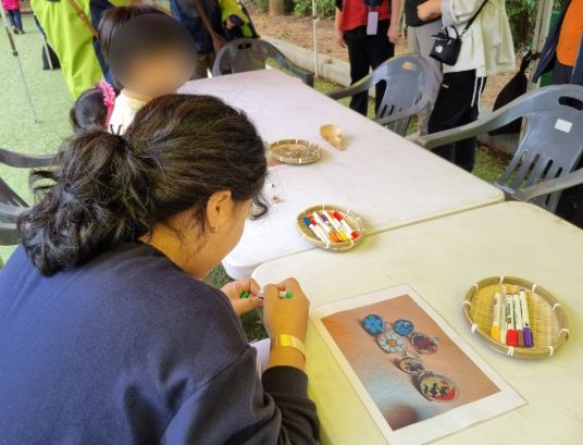 지난해 진행한 유아숲 페스티벌에서 아이와 부모가 함께 나무에 그림을 그리고 있다.