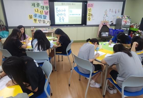 신일중학교 학생들이 세종대왕 탄신일을 맞아 한글 멋 글씨로 꾸민 물통을 제작하고 있다