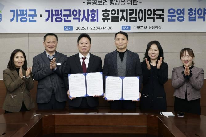 서태원 가평군수(사진 왼쪽에서 세번째)와 안병현 가평군약사회 회장(〃 네번째) 등이 22일 휴일지킴이약국 운영 협약식 후 협약서를 보이며 기념촬영을 하고 있다.