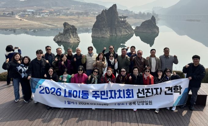 밀양시 내이동 주민자치회 회원들이 단양군 도담삼봉에서 선진지 견학 기념 촬영을 하고 있다.
