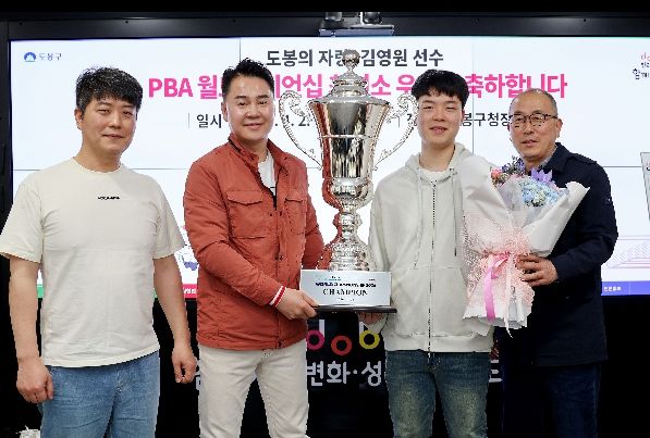 오언석 도봉구청장과 김영원 선수가 함께 트로피를 들고 기념사진을 찍고 있다