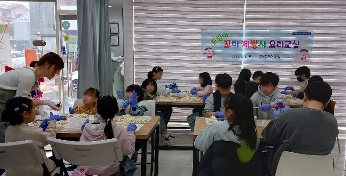 드림이 꼬마제빵사 요리교실에 참여한 아이들이 또래 친구들과 함께 소시지빵을 만들고 있다.